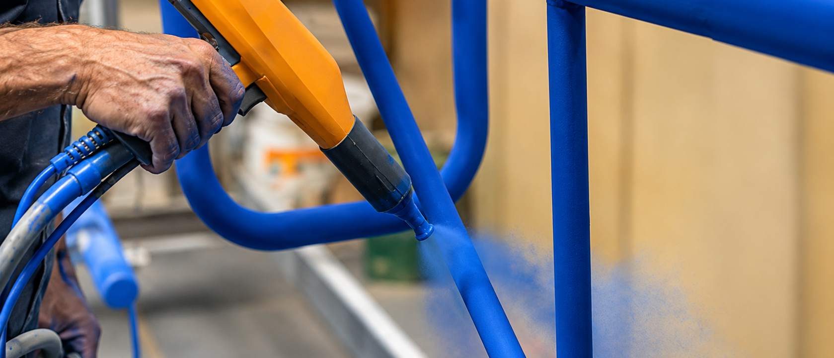 Powder coating being applied to an outdoor furniture frame